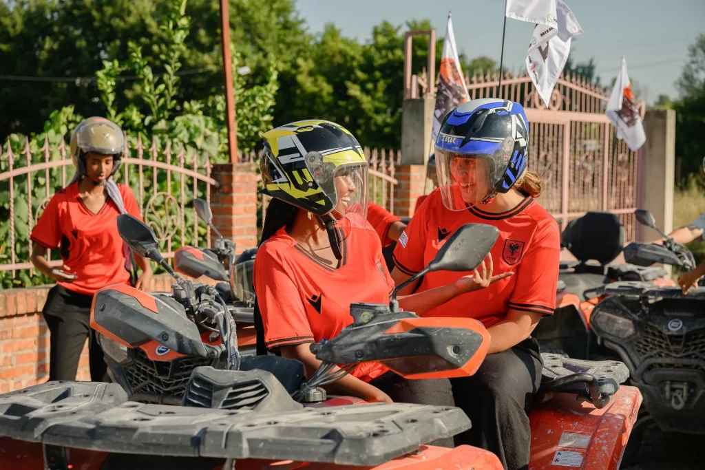 An ATV Tirana guide preparing safety helmets on the quad bikes before departure