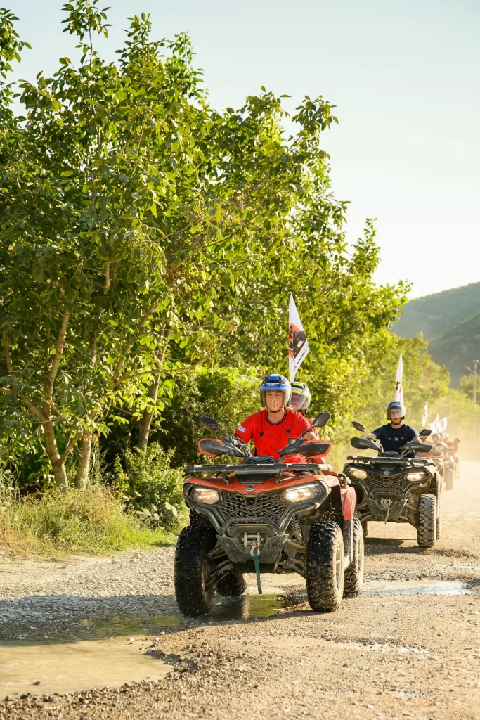 A guest in a red shirt riding a quad bike with the ATV Tirana convoy