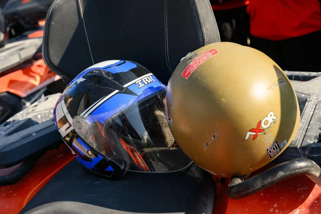 Two safety helmets ready on the seat of an ATV Tirana quad bike
