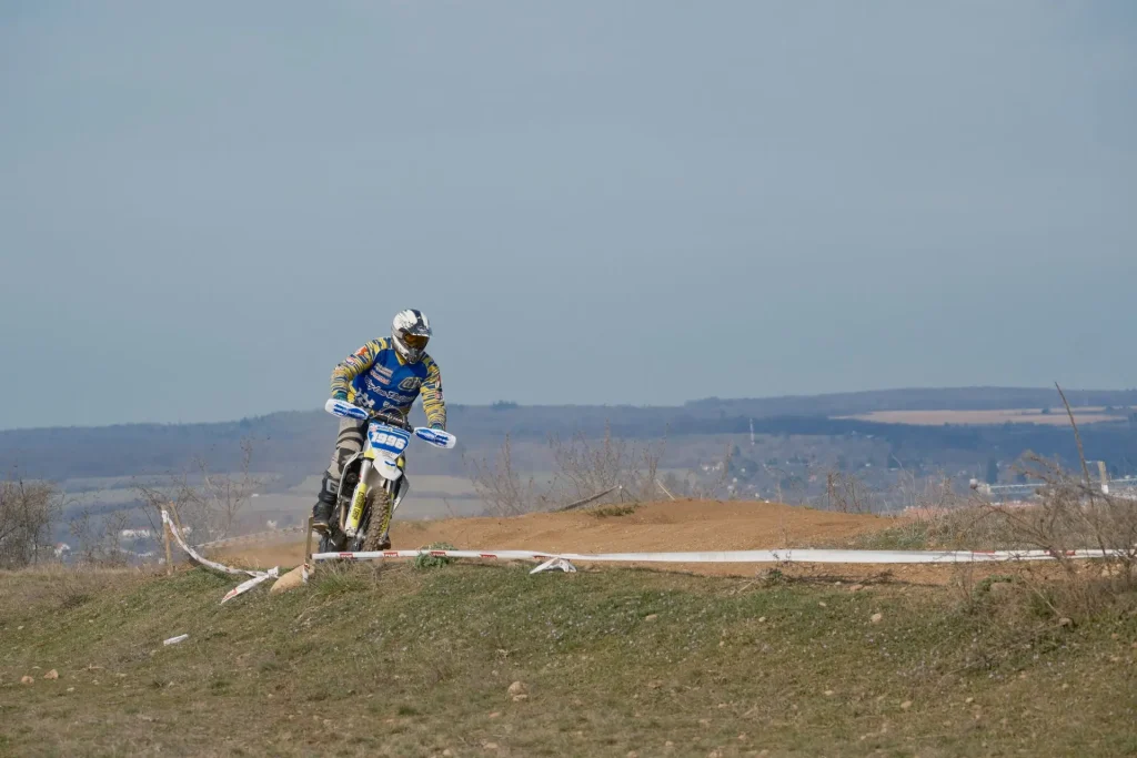 Illustrative enduro rider crossing a countryside dirt track