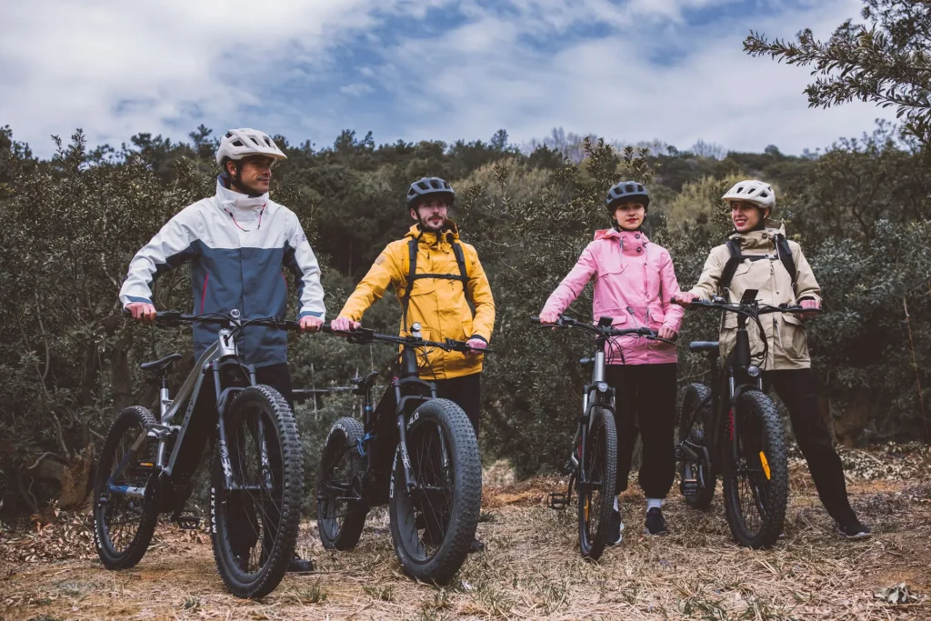Illustrative group of mountain-bike riders pausing together on a woodland trail