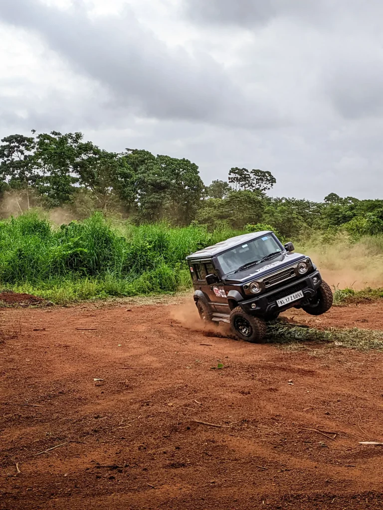 Illustrative 4x4 vehicle negotiating a steep red-dirt trail